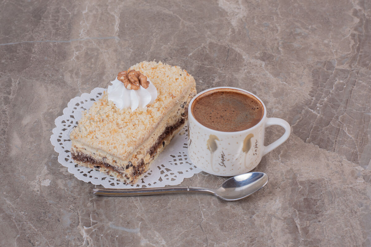 勺子美味的蛋糕和一杯咖啡放在大理石表面美味块蛋糕