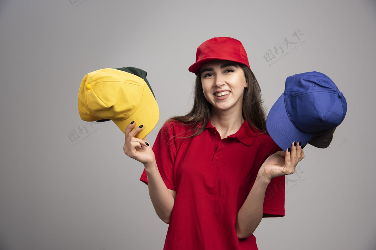 帽子一个穿着红色制服 戴着彩色帽子的送货员工人女帽子