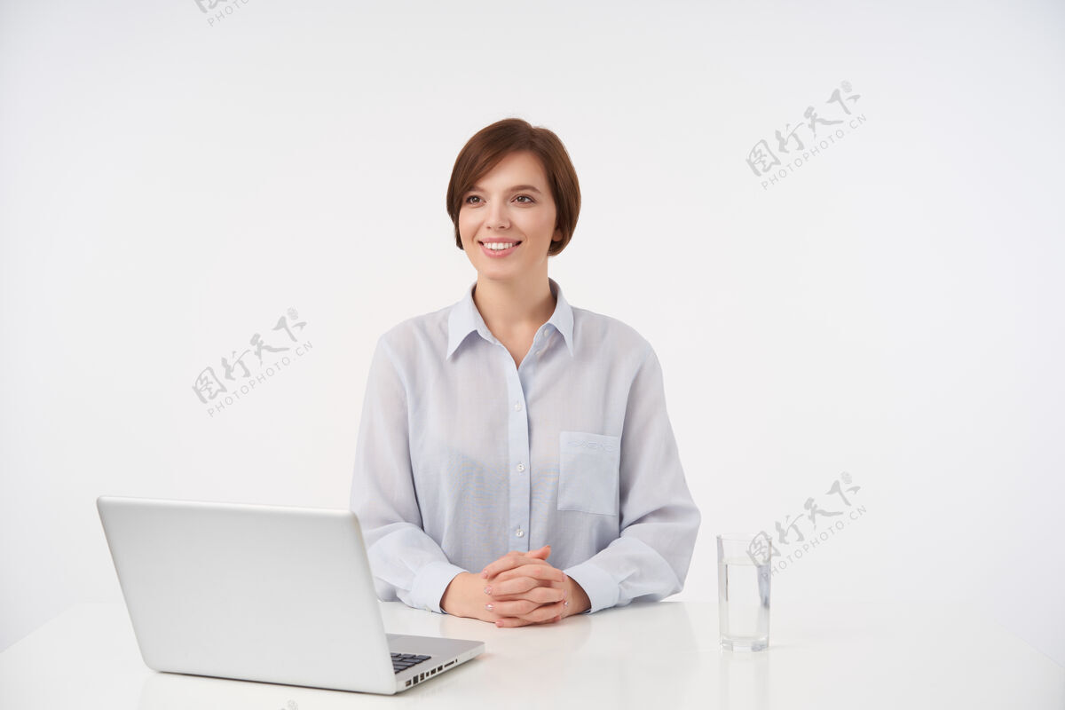 女人快乐的年轻棕色头发的女员工坐在白色的笔记本上 准备开会 面带积极的微笑精神现代员工