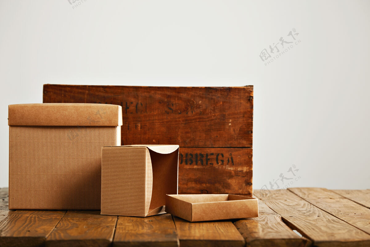 交货模拟空白米色纸盒旁边的一个复古粗糙的棕色木箱隔离在白色移动旧的工厂