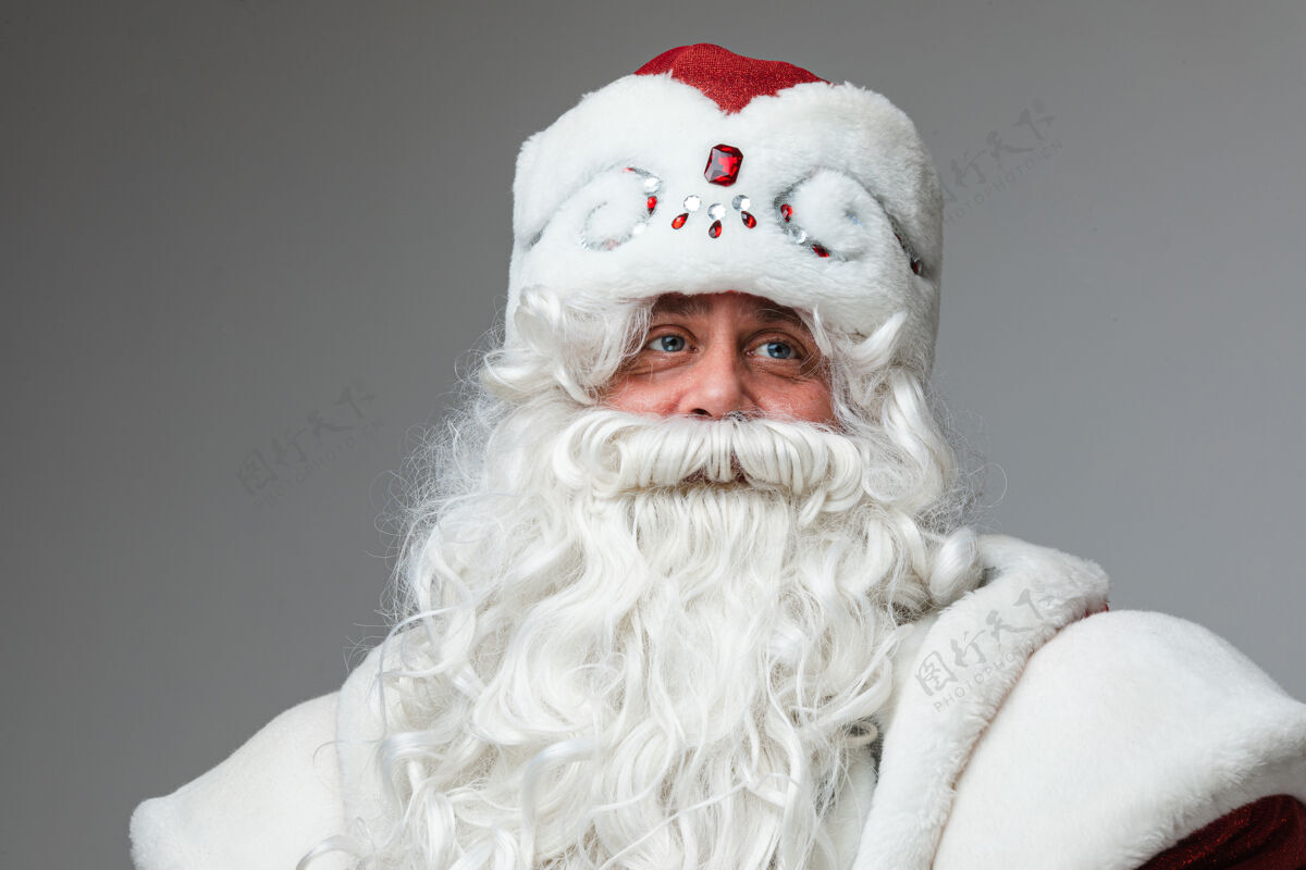 节日戴着圣诞帽 留着灰胡子和小胡子的成熟男人圣诞老人圣诞老人庆祝