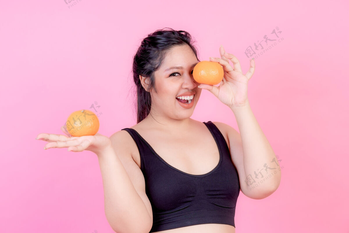 测量超重的亚洲丰满女性与橙色体重热量食物