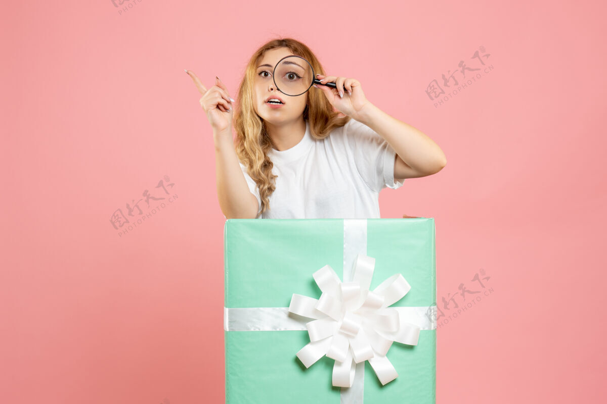 礼物前视图年轻女性在蓝色礼品盒内使用放大镜使用情感粉色
