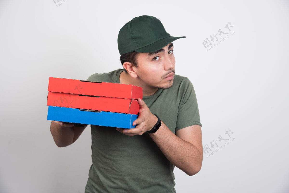 工人年轻的信使拿着三盒白底披萨送货员搬运男人