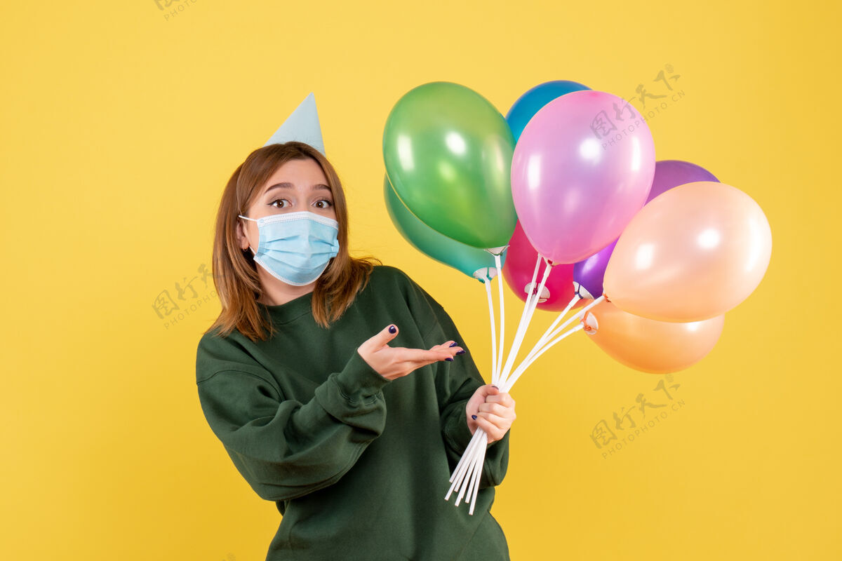 节日正面图：手持彩色气球的年轻女性气球生日庆祝