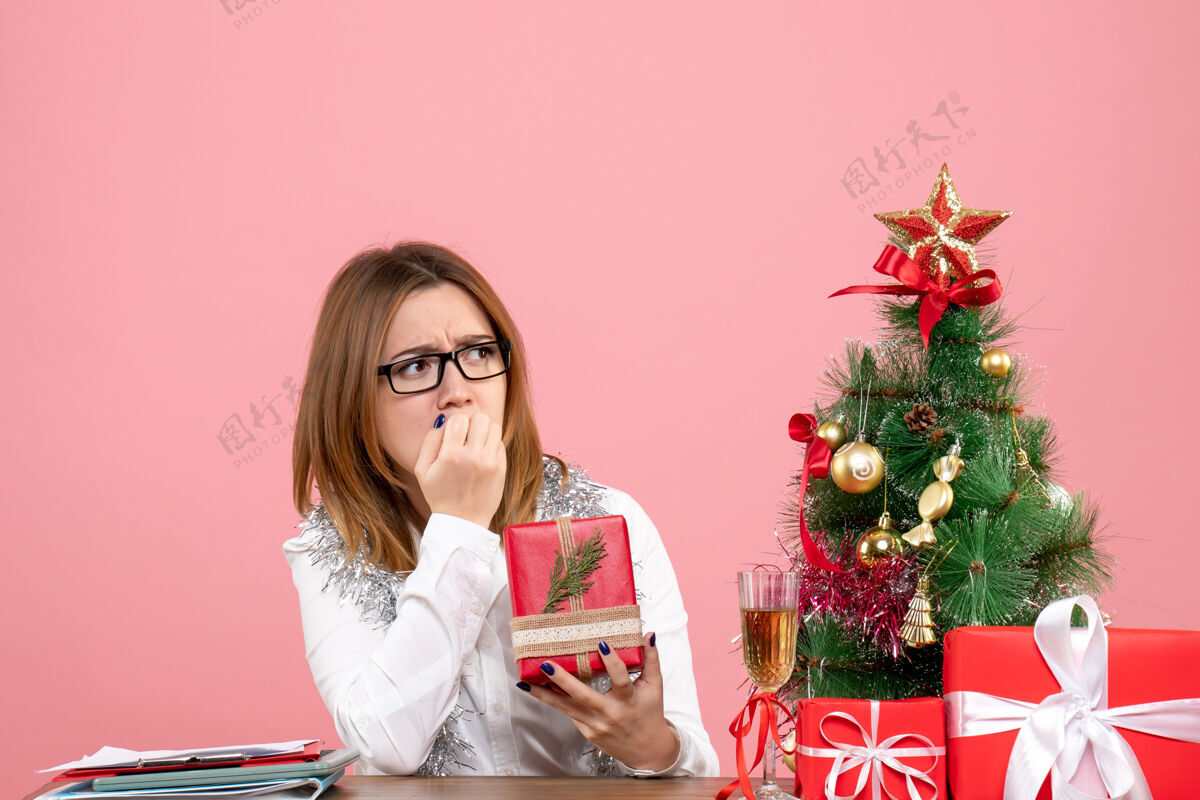 女性女工正坐在粉红色的椅子上 手里拿着圣诞礼物女工肖像人