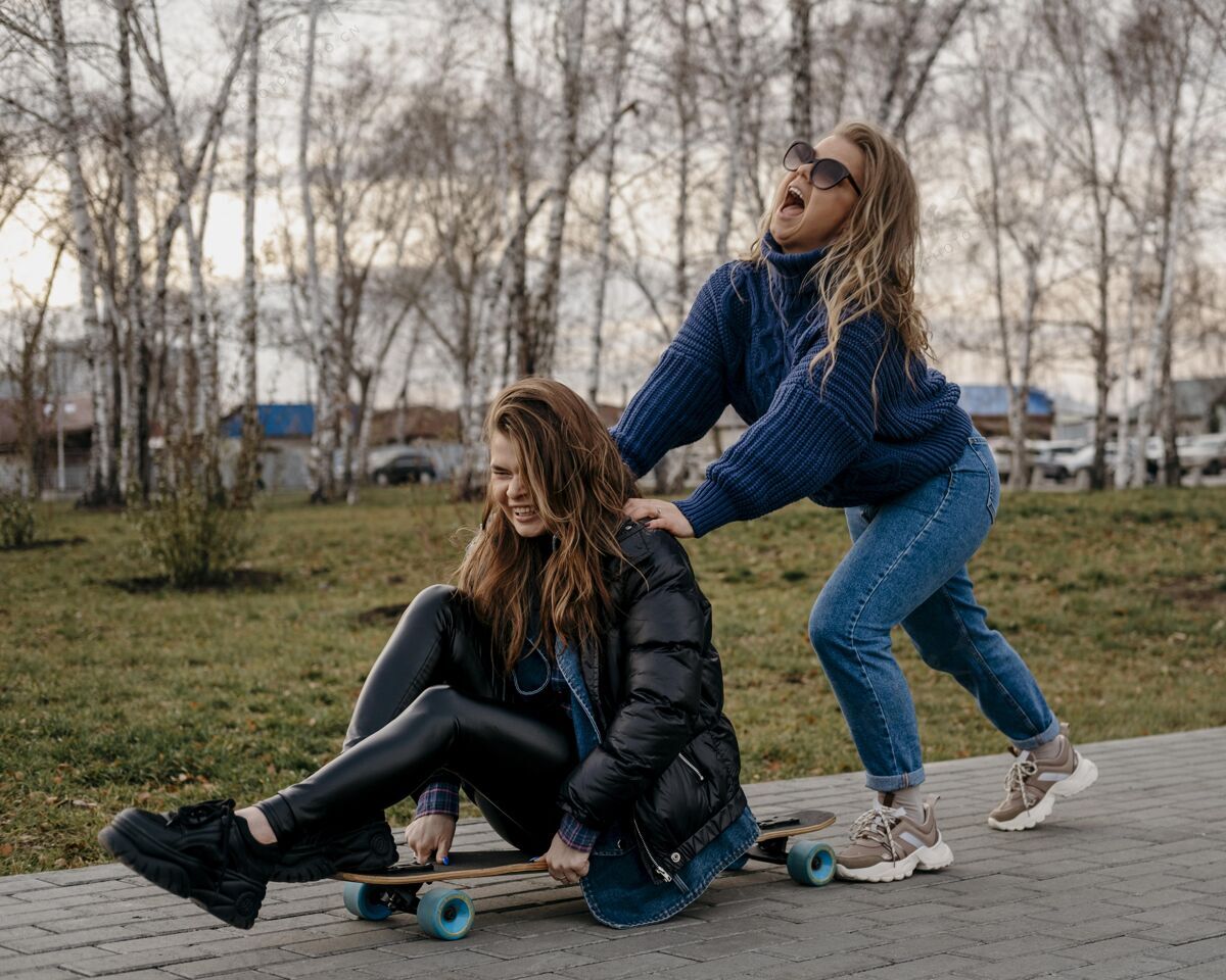 朋友女性朋友在户外玩滑板乐趣滑板在一起