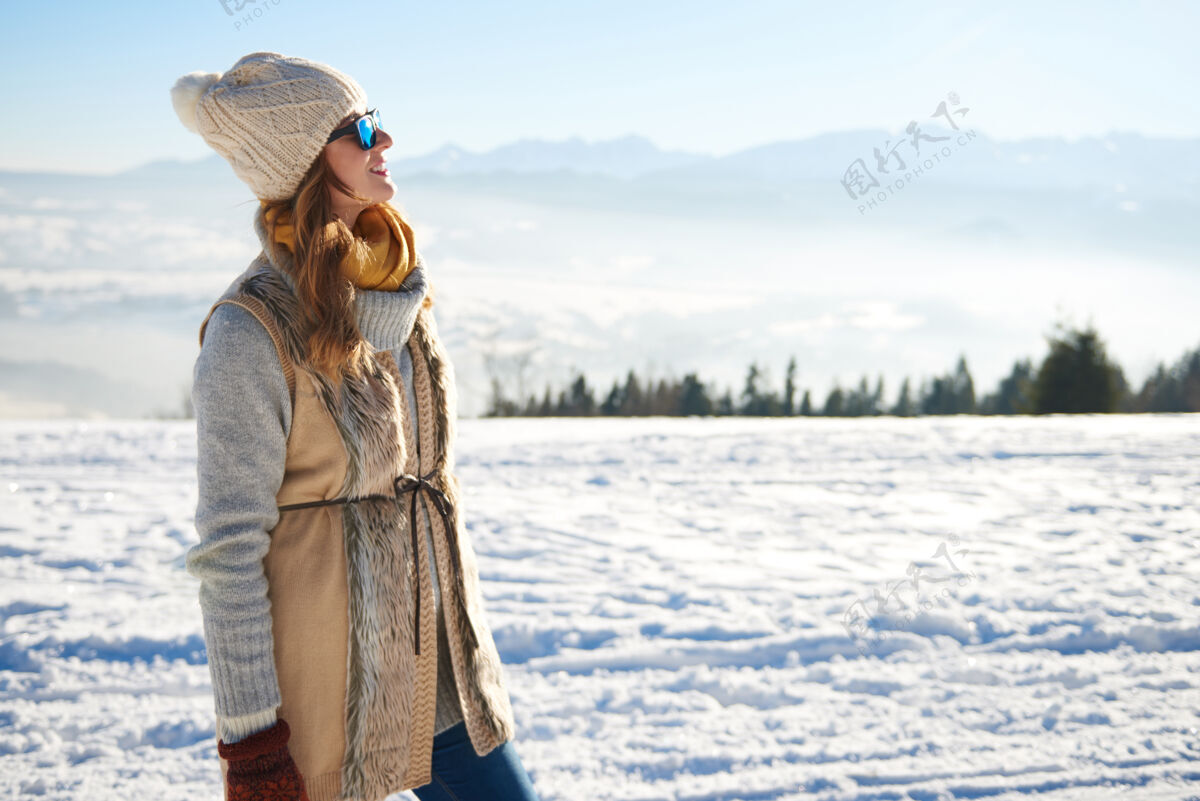 阳光看山景的女人牙齿滑雪探索