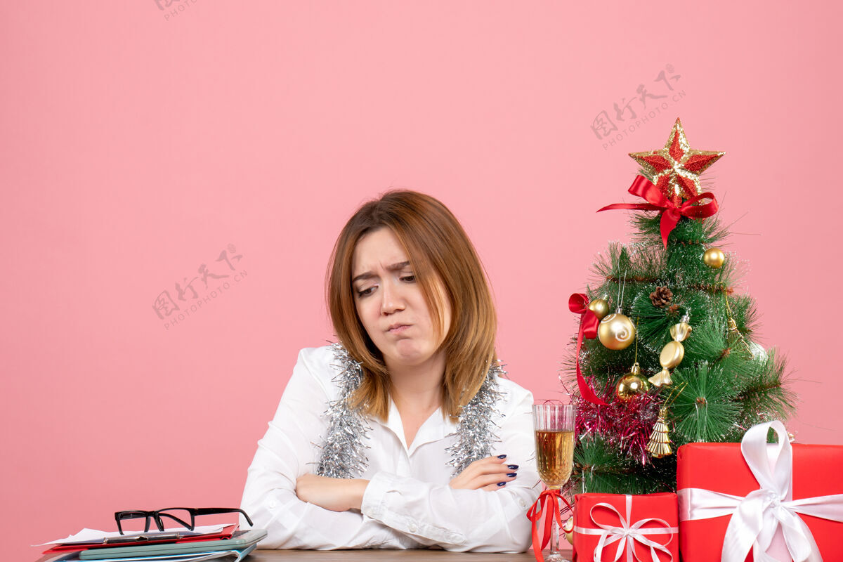 坐着女工围坐在粉色的圣诞礼物旁的正视图情感礼物粉色