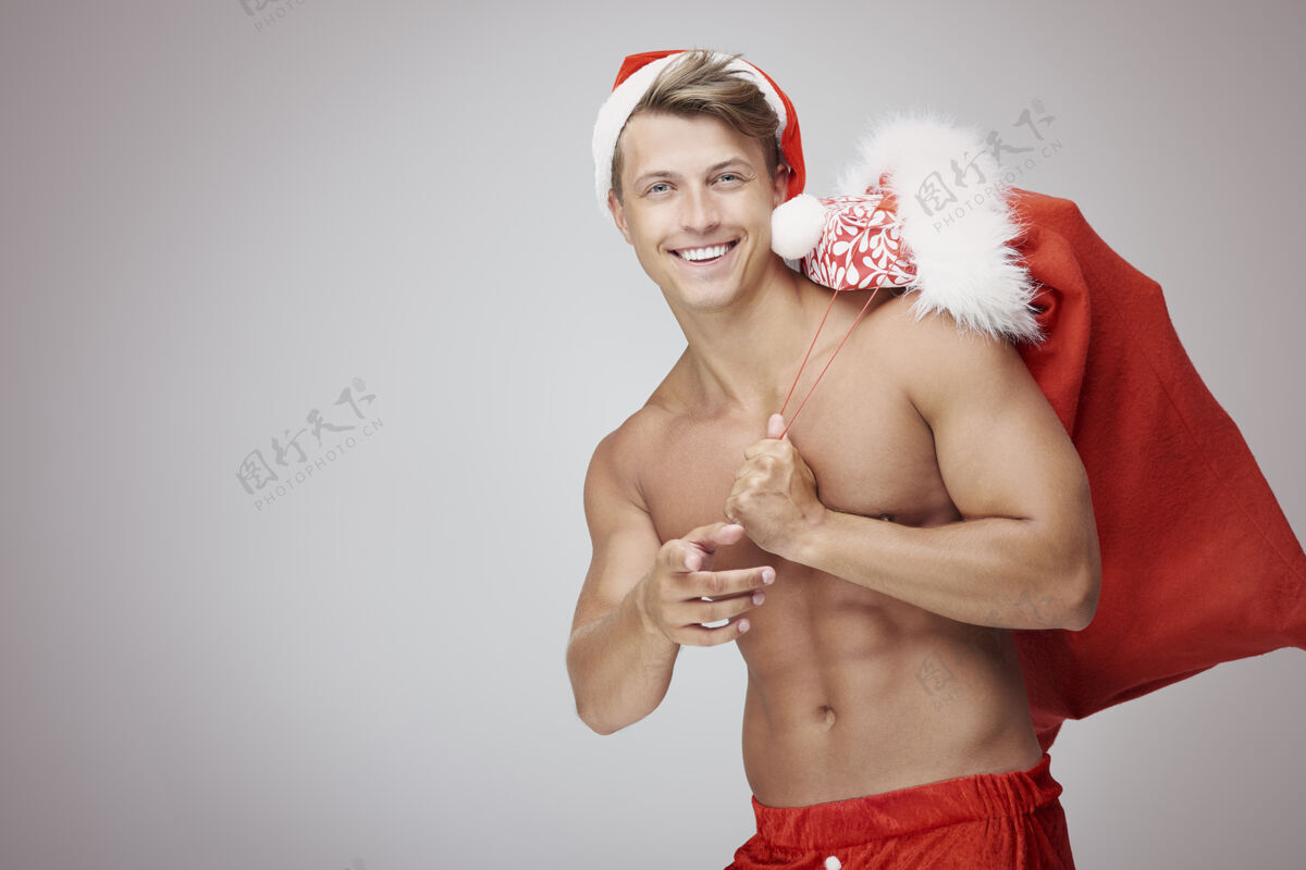 肌肉建设赤膊男人和圣诞袋肌肉英俊显示