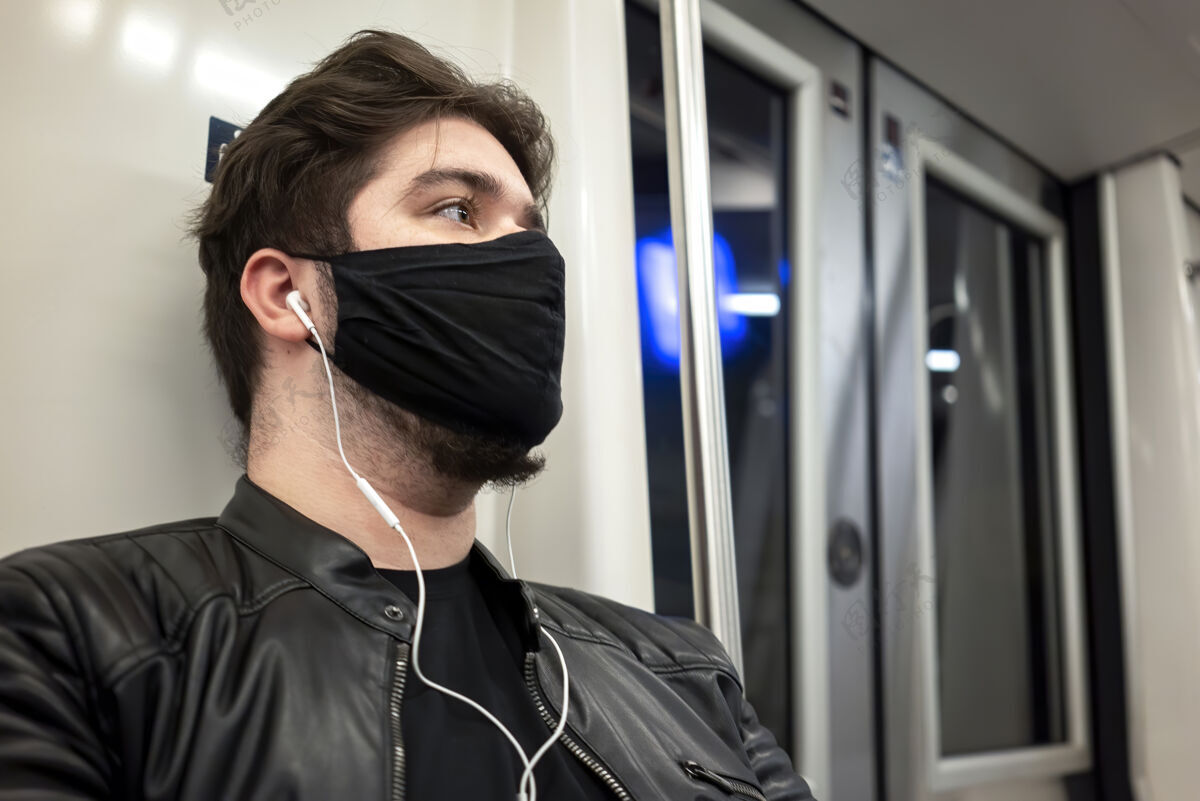 面罩地铁里一个留着胡子戴着耳机戴着黑色医用面罩的白种人医疗医疗预防