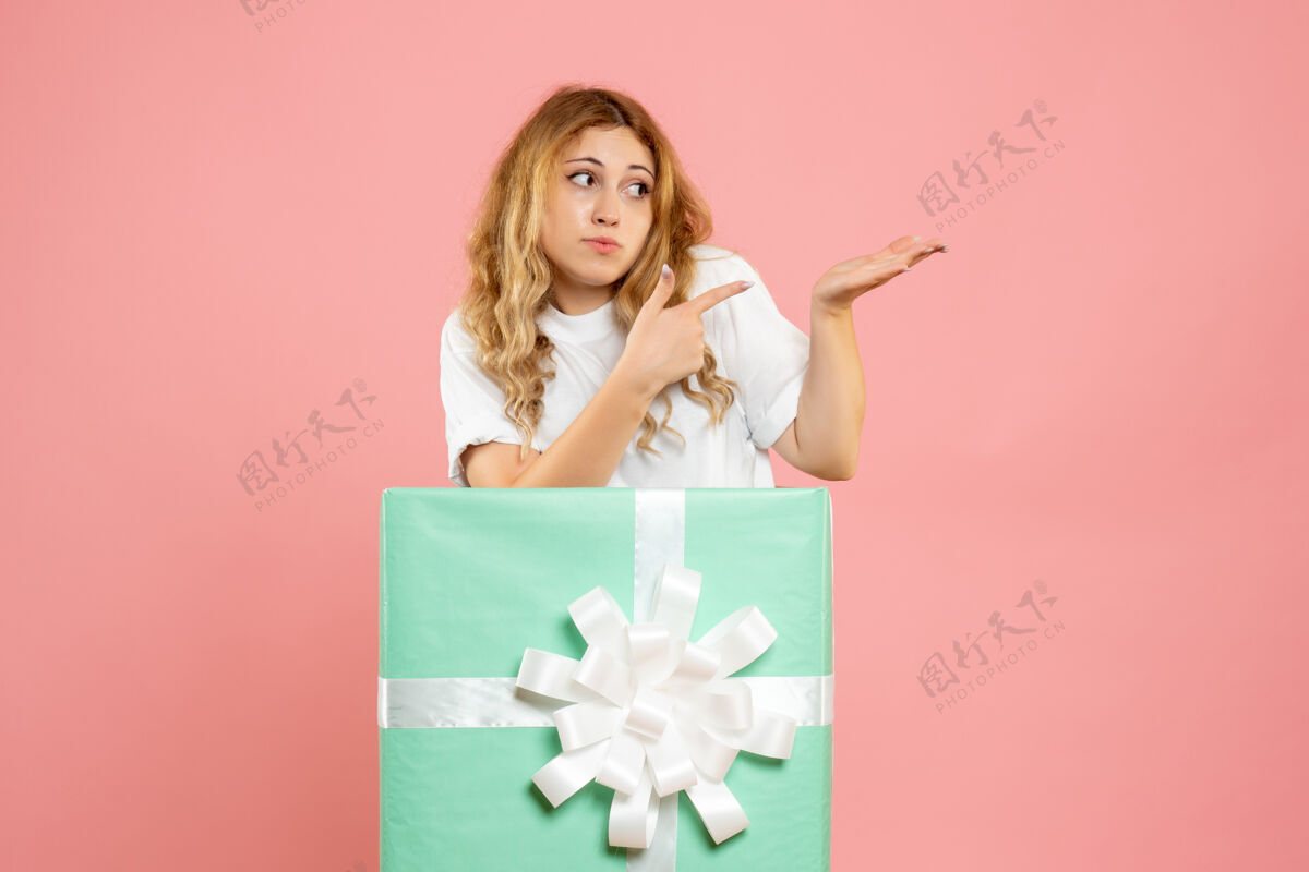 聚会正面图：站在蓝色礼品盒内的年轻女性圣诞节年轻站立