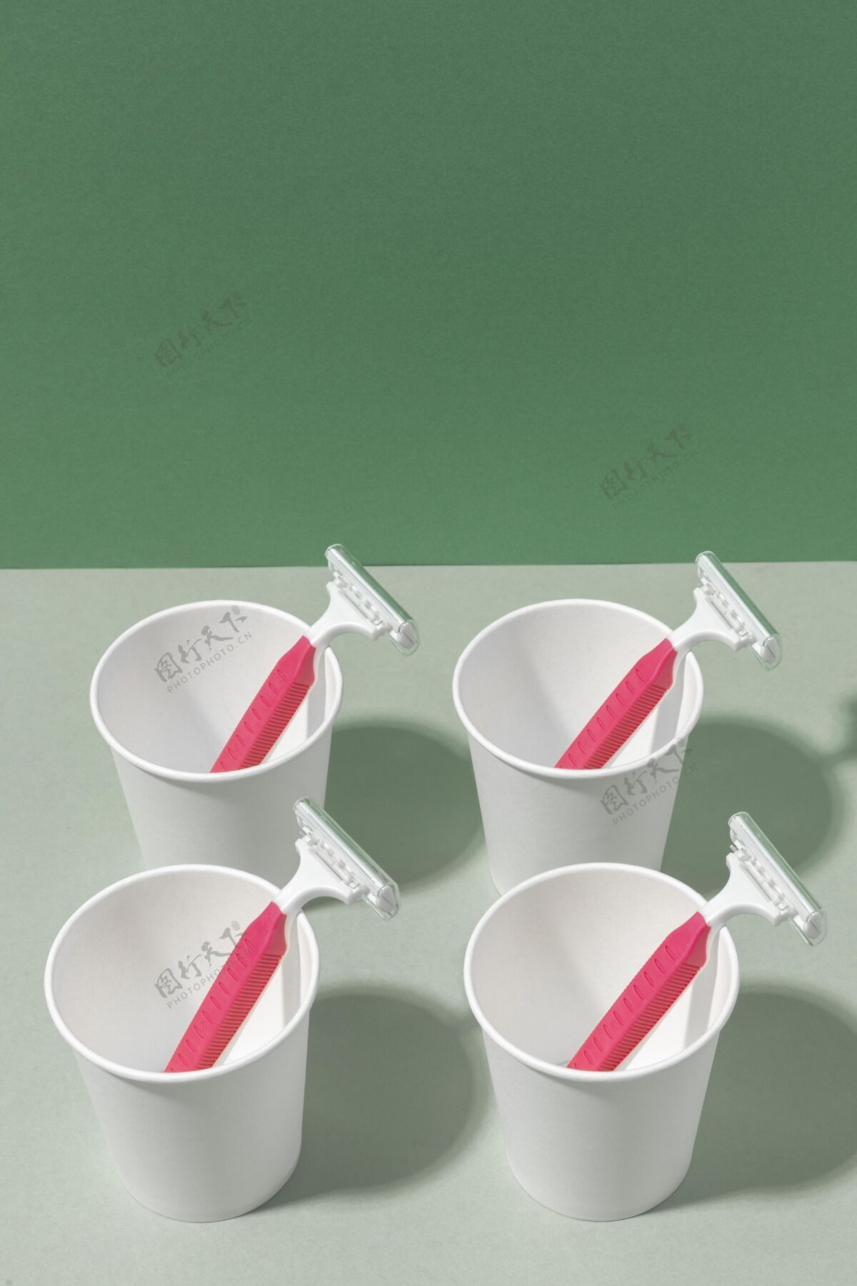 垃圾粉红色剃须刀片和杯子的排列污染产品一次性