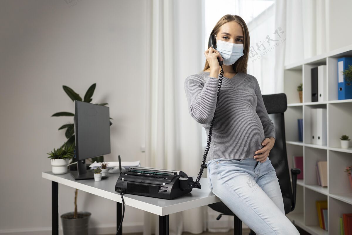 电脑孕妇戴着医用口罩在办公室接电话医疗口罩母亲职业