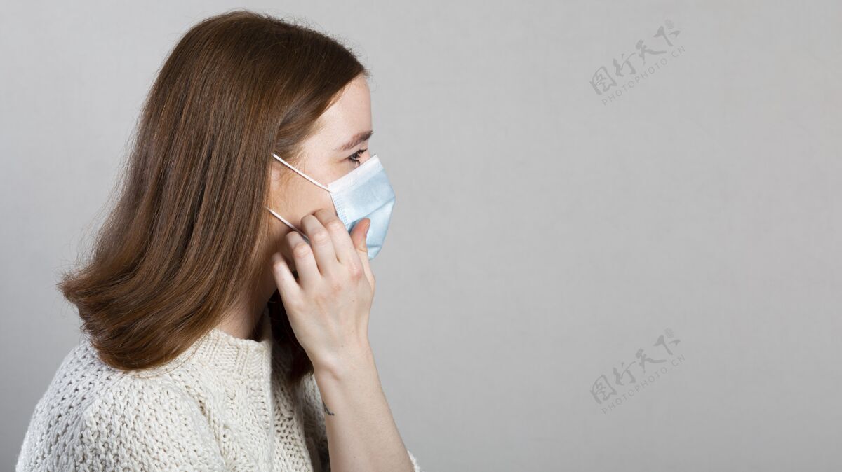 面罩侧视图的妇女使用医用口罩保护与复制空间流行病防护预防