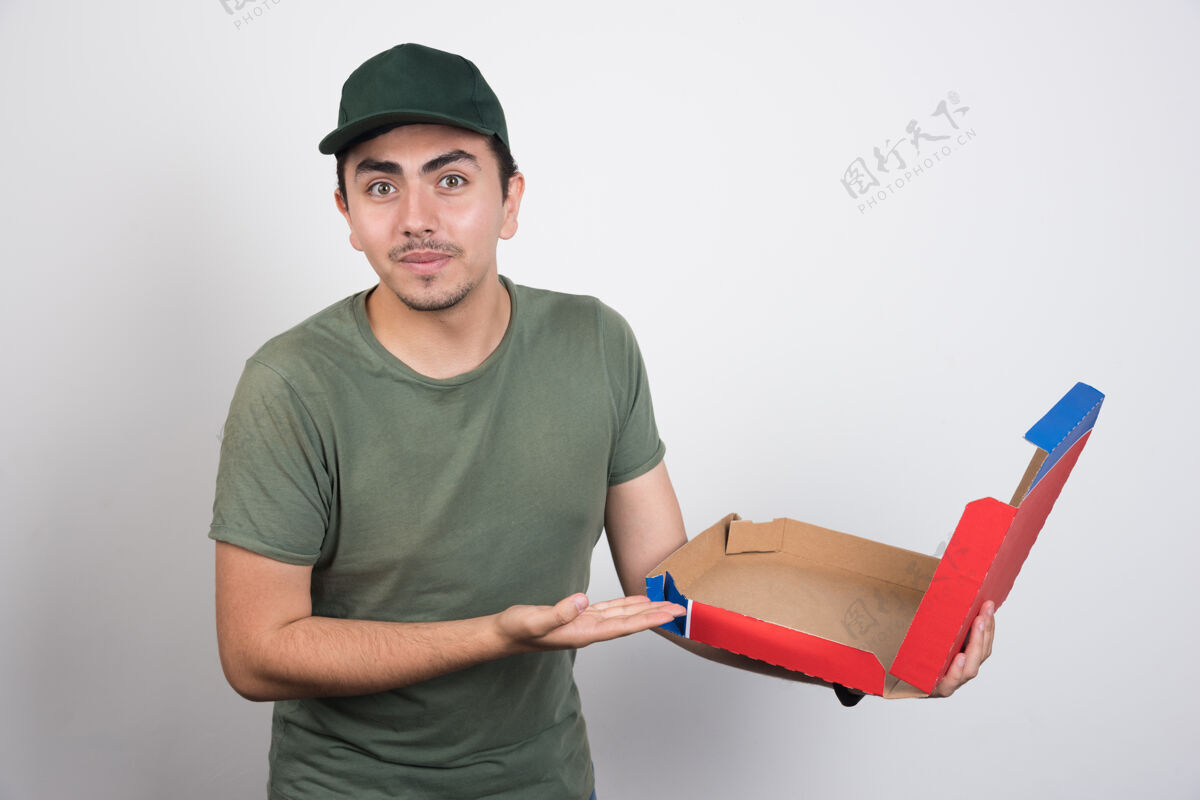 肖像送货员指着白色背景上的空比萨饼盒工人男人外卖