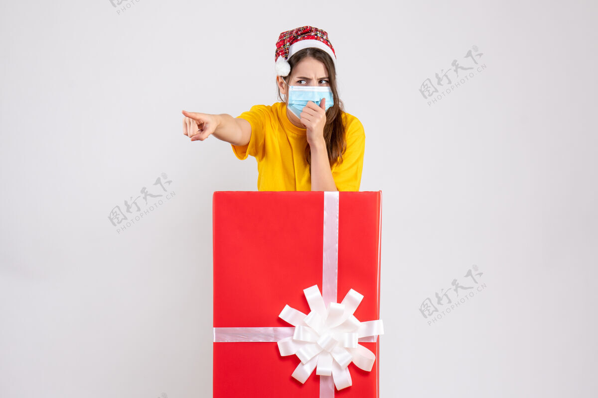 什么带着圣诞帽的怀疑女孩指着白色圣诞礼物后面的东西圣诞节指着怀疑