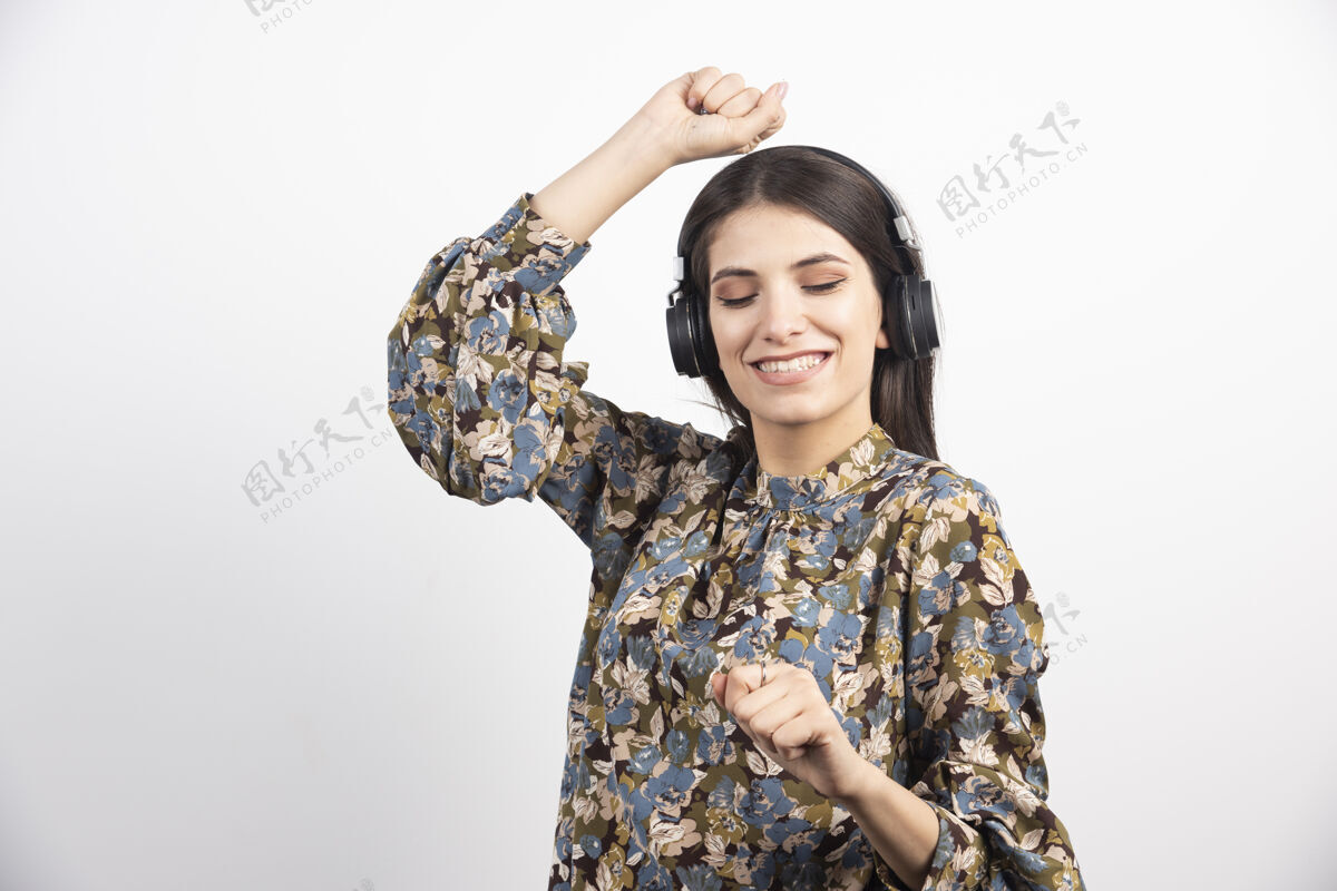 女人黑发女人听着音乐 带着快乐的表情跳舞肖像听女人