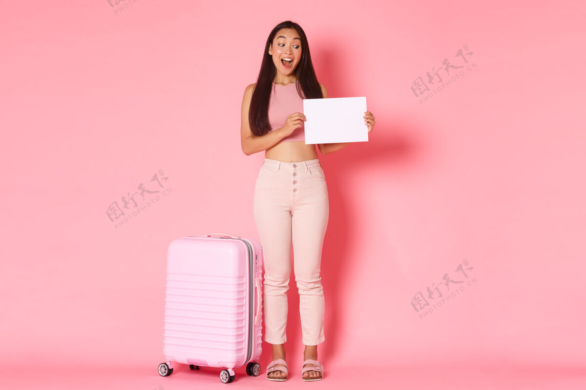 微笑带着手提箱的年轻女子无忧无虑旅游肖像