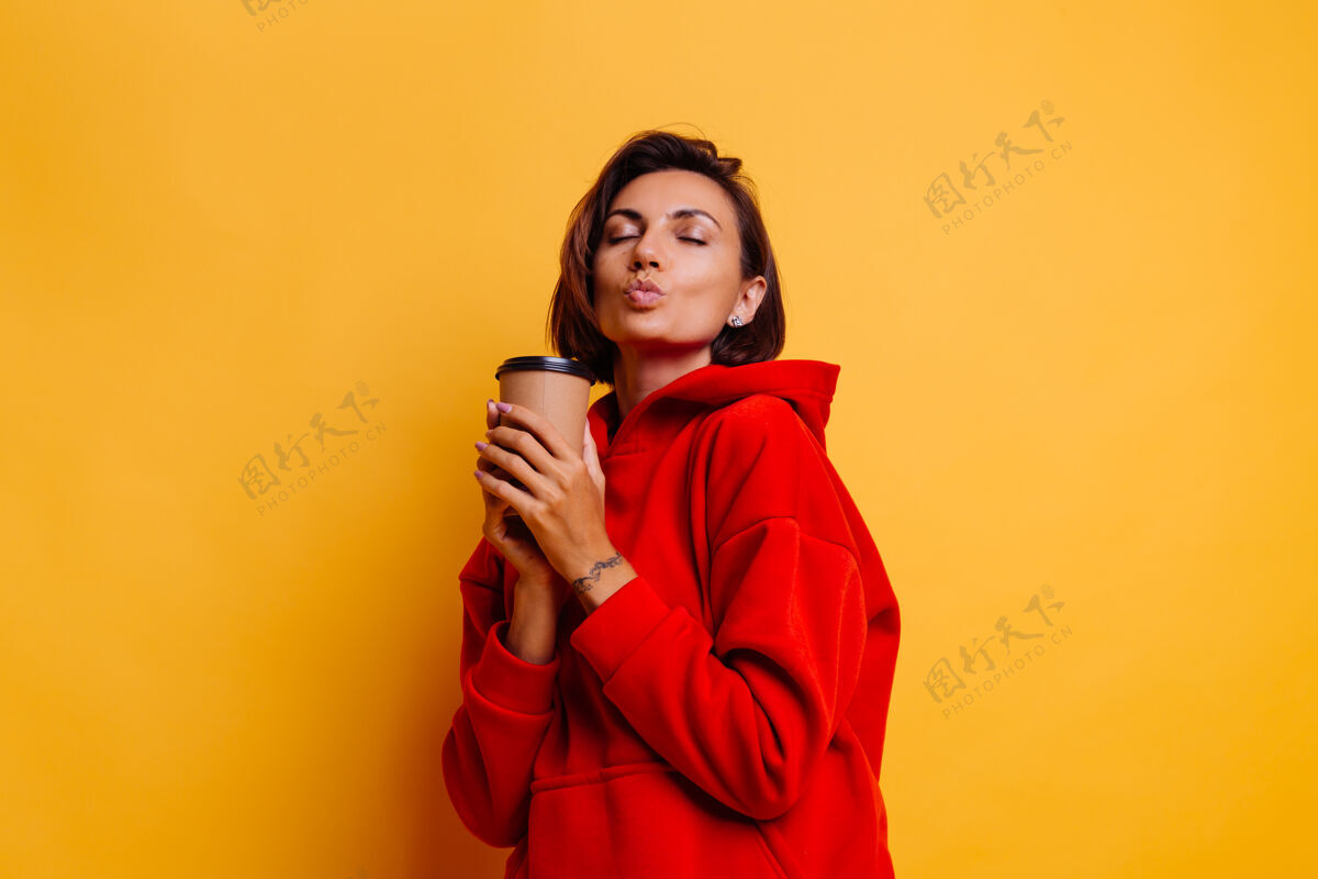 毛衣快乐的女人穿着暖和的冬衣 用一杯热咖啡取暖杯子空间复制