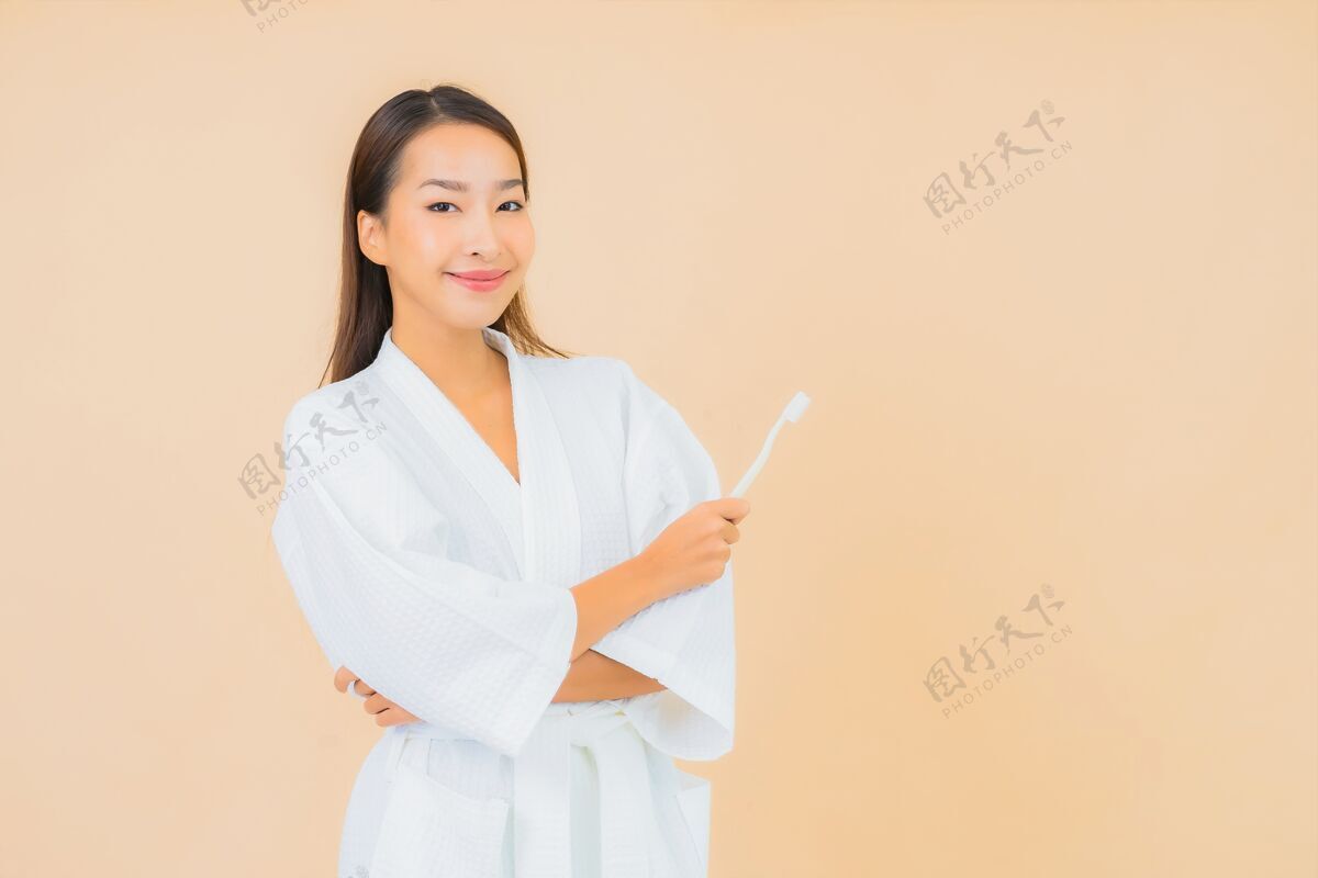 刷子用米色牙刷描绘美丽的亚洲年轻女子成人口腔女性