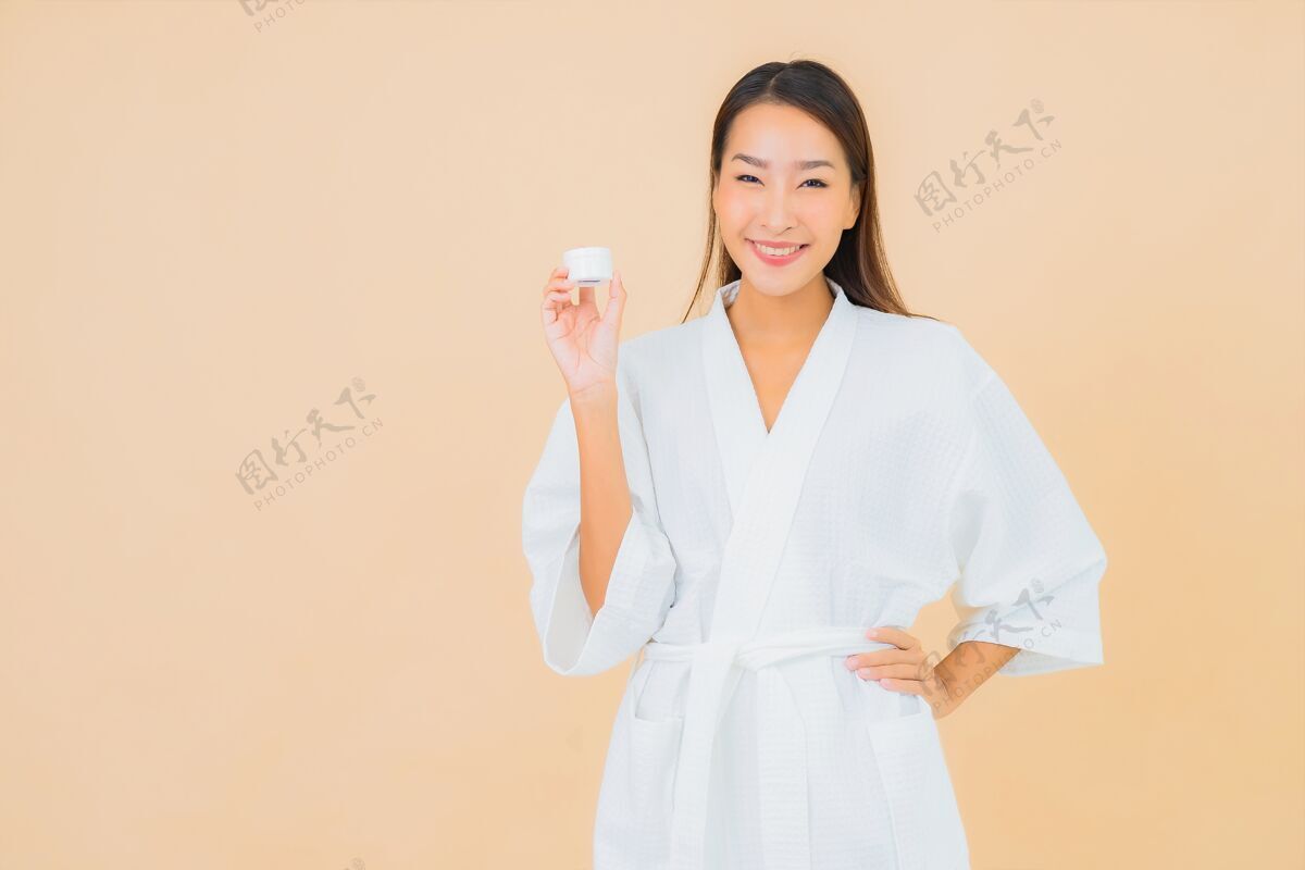 自然肖像美丽的亚洲年轻女子与瓶乳液和面霜米色东方人韩国健康