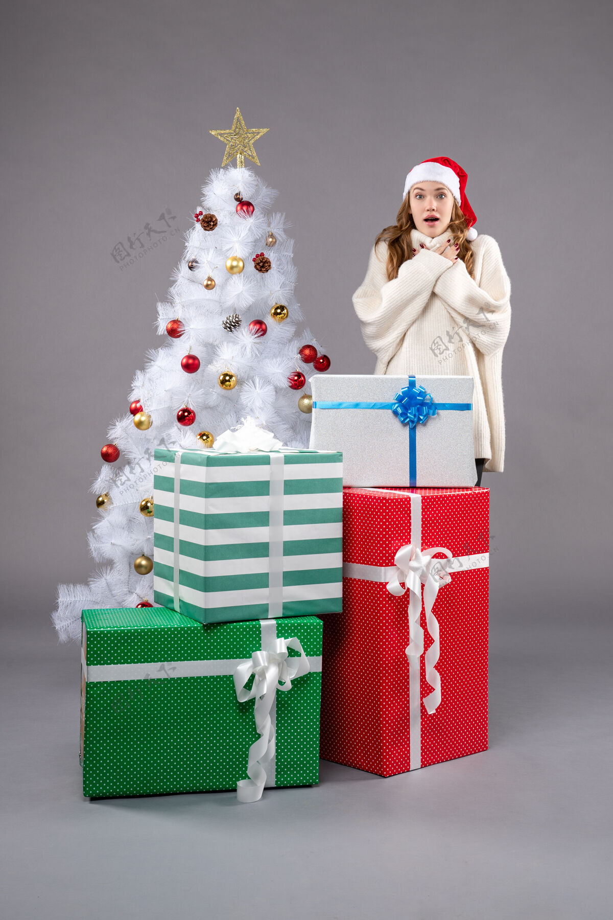 灯年轻的女性在灰色的礼物圣诞树时尚圣诞老人