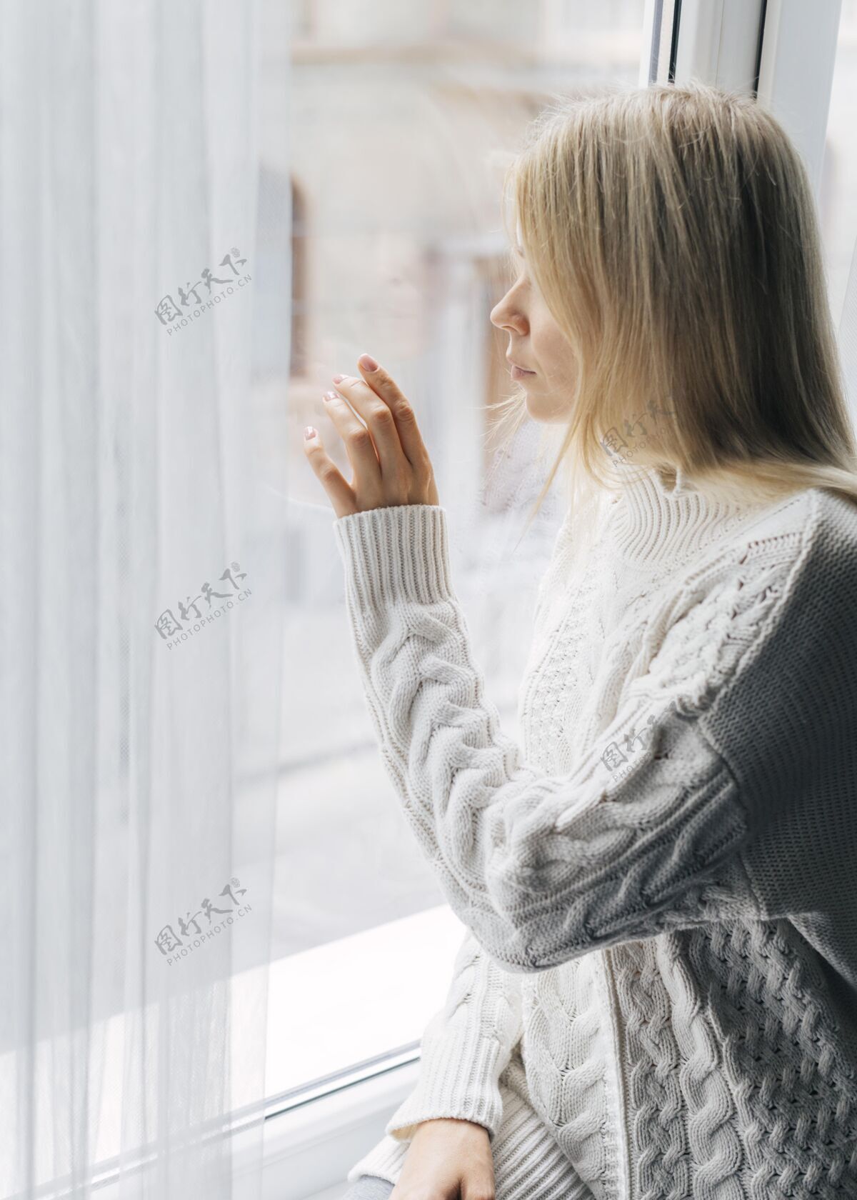 隐居大流行期间妇女在家的侧视图透过窗户看冠状病毒隔离防护