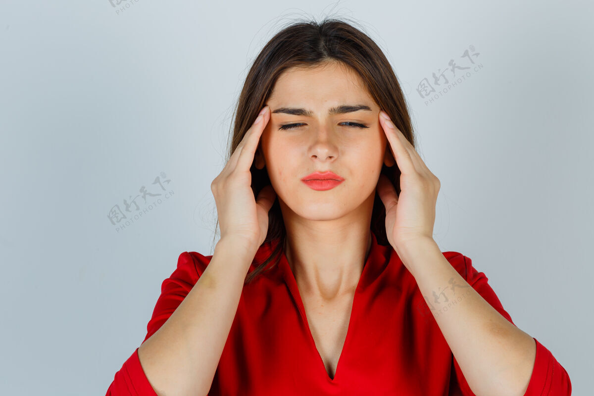 人穿着红衬衫的年轻女士揉着太阳穴 看上去筋疲力尽迟到头痛压力