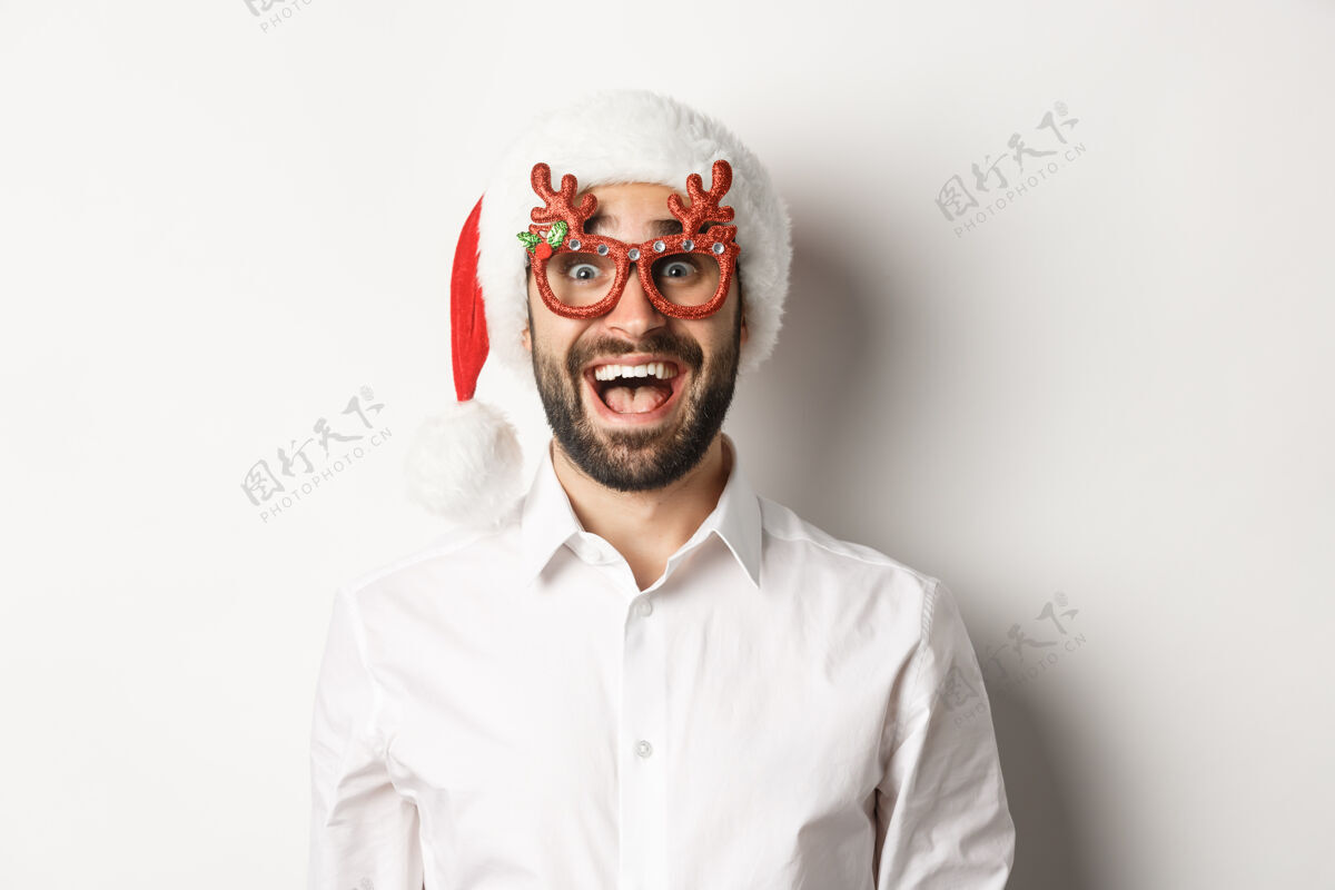 男人特写镜头中的兴奋的胡须男子在圣诞眼镜和圣诞帽看惊喜的促销优惠 寒假广告的概念圣诞老人成人幸福