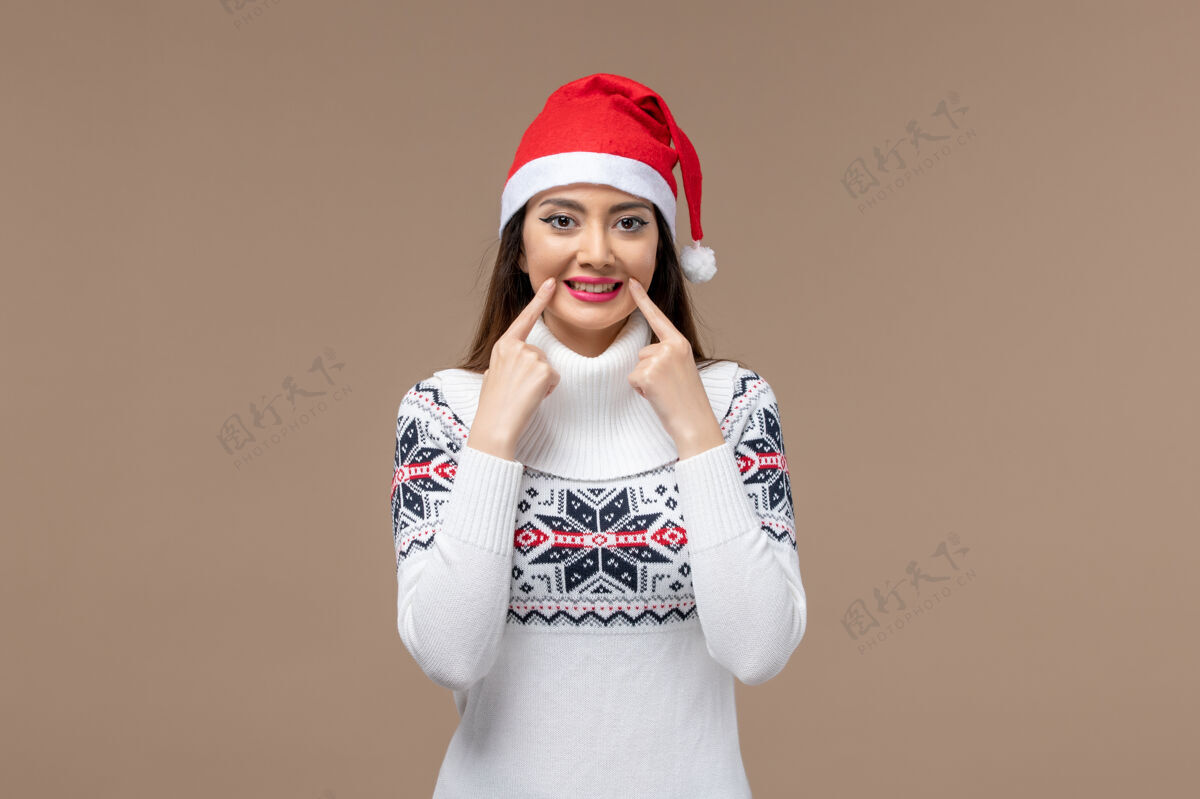 微笑正面图：年轻女子在棕色背景上微笑 感慨圣诞新年年份圣诞节背景