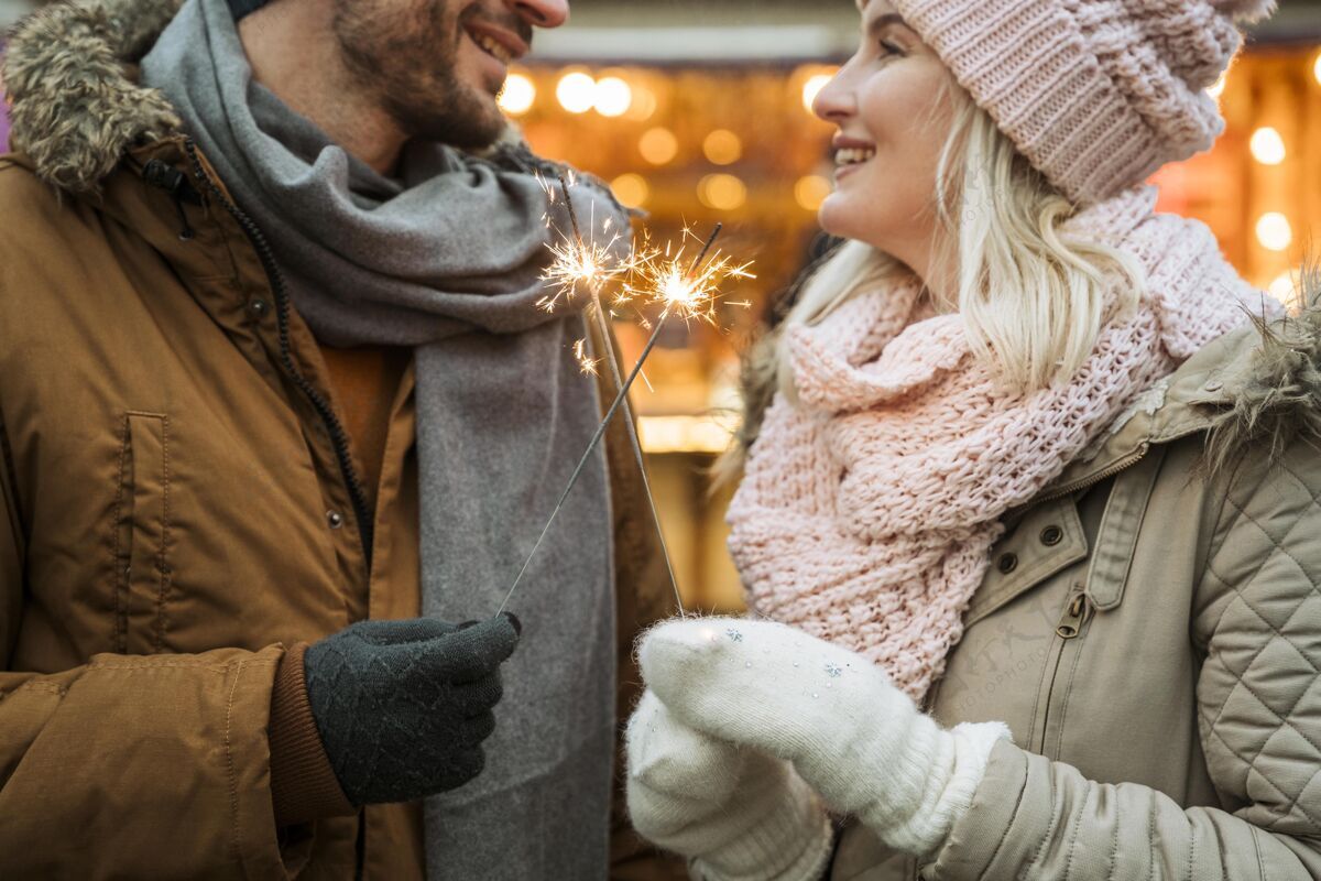 年轻冬天的情侣穿着夹克和围巾关系在一起结合