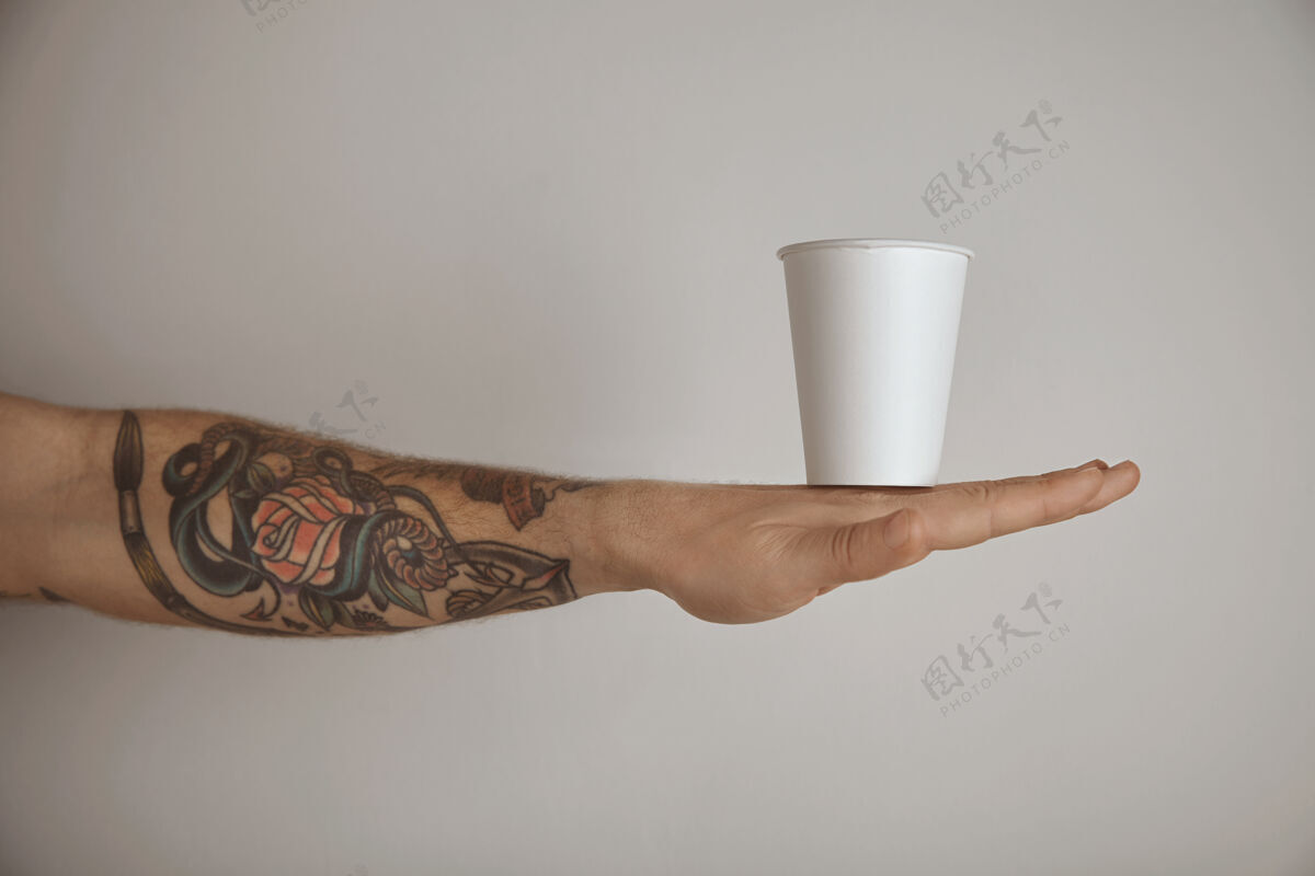 早餐空白带走纸玻璃纹身野蛮男子的手 侧视图介绍孤立的白色背景杯子手牛奶
