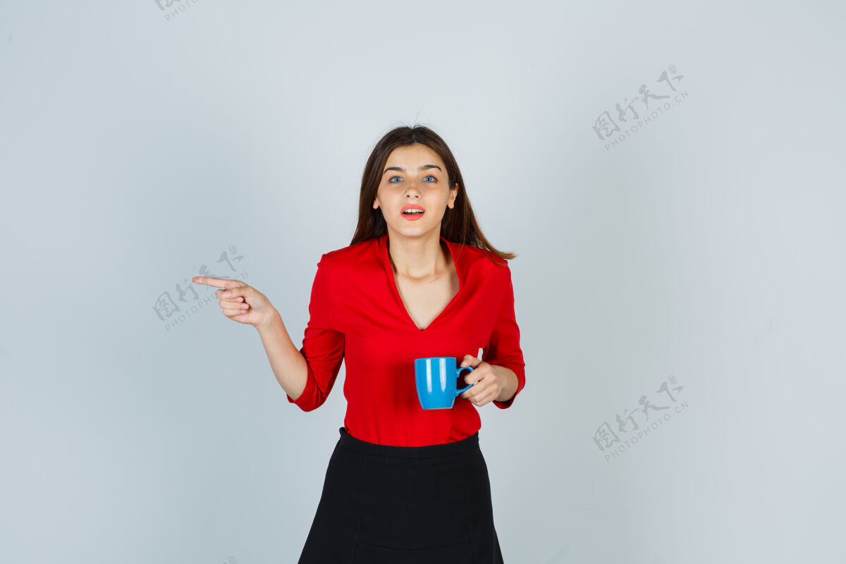 裙子年轻的女士拿着杯子指着左边的红衬衫一边青少年青年