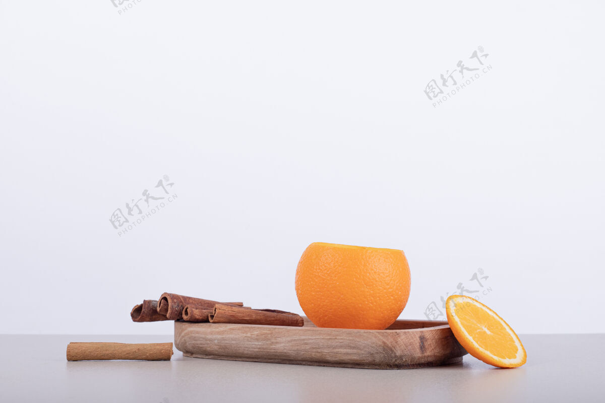 果汁橘子汁里加肉桂放在白色盘子里甜味橙子盘子