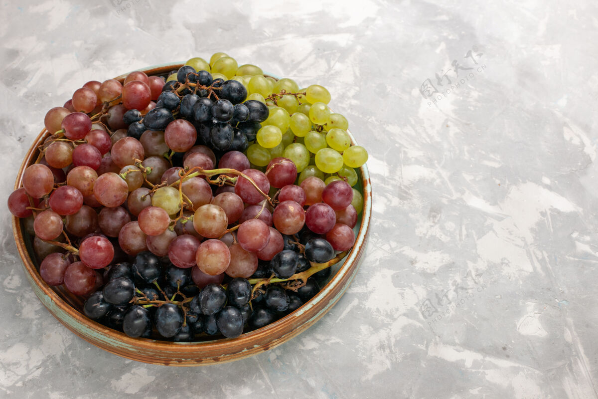 酸的前视不同葡萄多汁醇厚酸味水果浅白桌上水果新鲜醇厚果汁酒可食用的水果不同的桌子