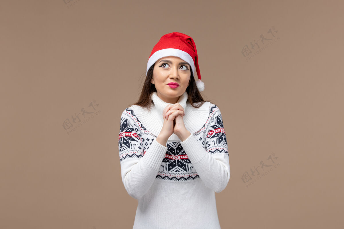 年轻前视图年轻女子与梦想的棕色背景圣诞新年情感表达帽子漂亮快乐