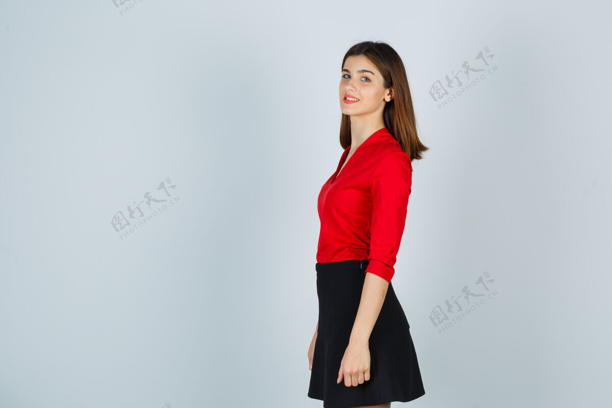 人穿红衬衫 黑裙子的年轻女人 看起来很快乐女人快乐裙子