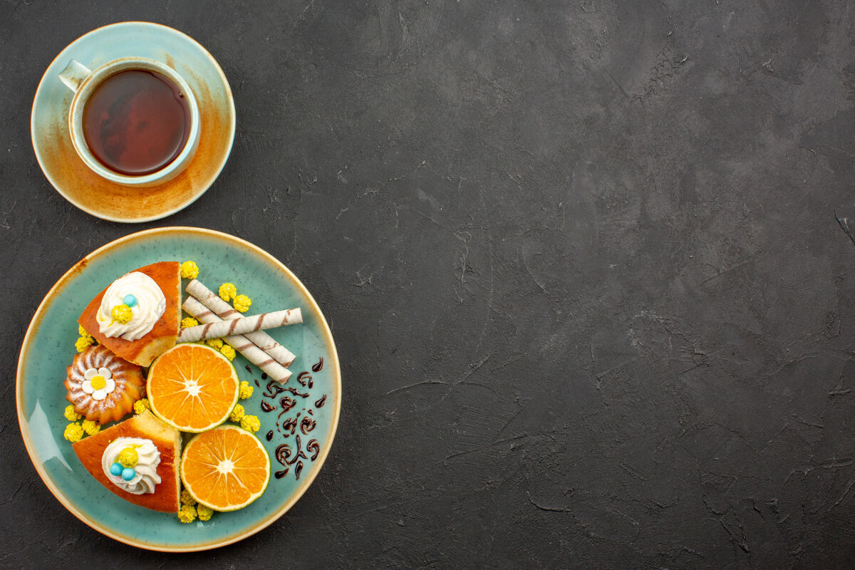 饮料顶视图美味的派片与新鲜的橘子和一杯茶在黑暗中饮料饼干早餐
