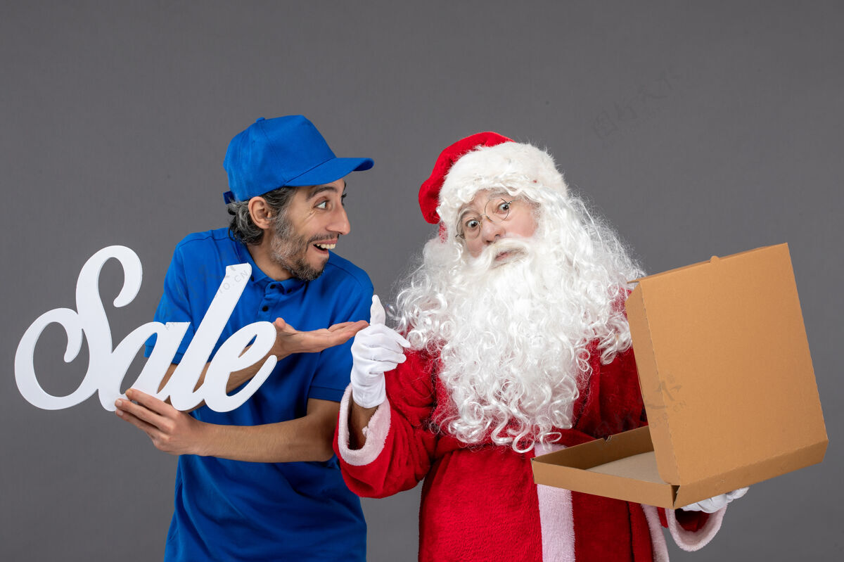 十二月圣诞老人的正面图 男信使拿着卖东西的字条 灰色墙上还有空的食品盒食品空写作
