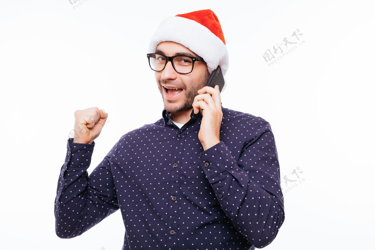 休闲一个戴着圣诞帽的年轻人在打电话和欢呼男人拉丁语年轻