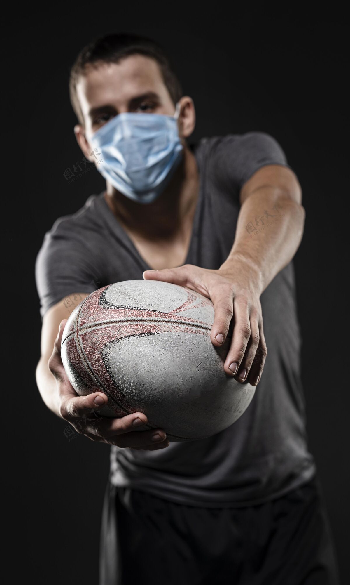 活动手持医用面罩持球的男橄榄球运动员的前视图完全接触锦标赛体育