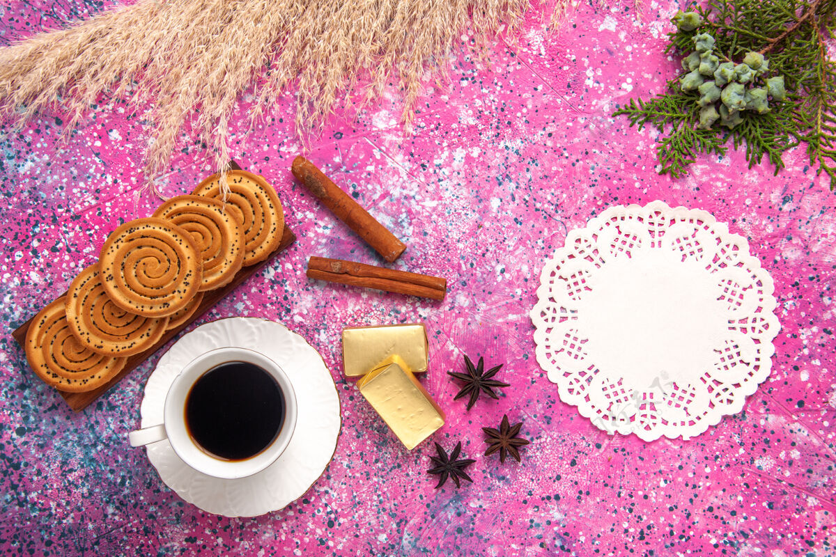 杯子一杯茶 配上饼干和肉桂 放在浅粉色的桌子上饮料茶糖