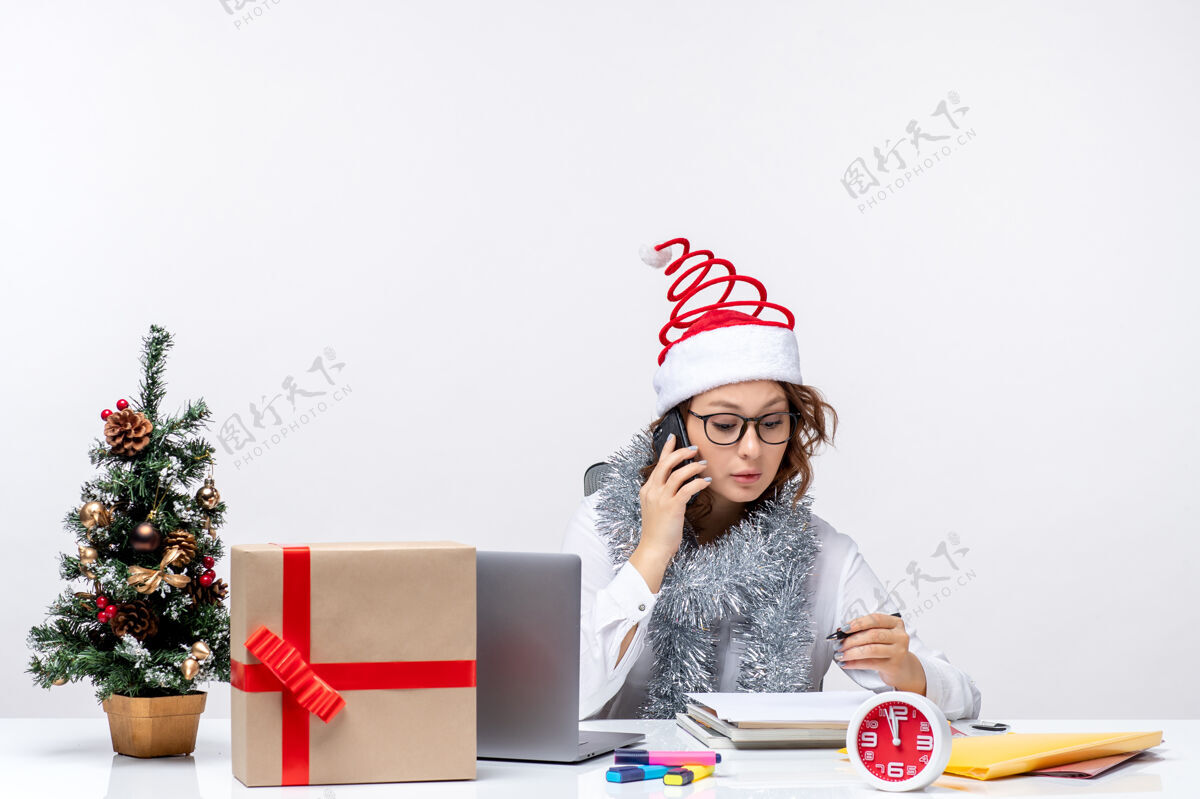 交谈正面图：假日工作的年轻女性在白色背景下打电话礼物白色圣诞节