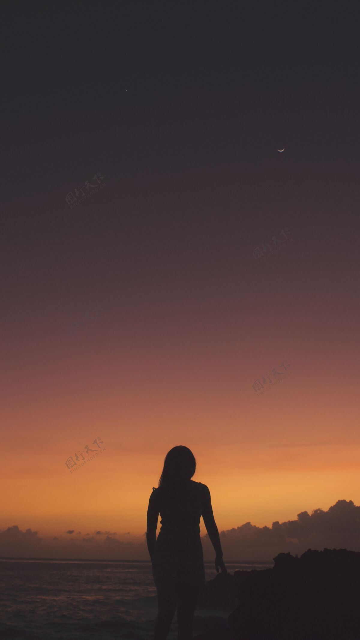 日落夕阳下 一个女人站在海边的悬崖上徒步阳光山