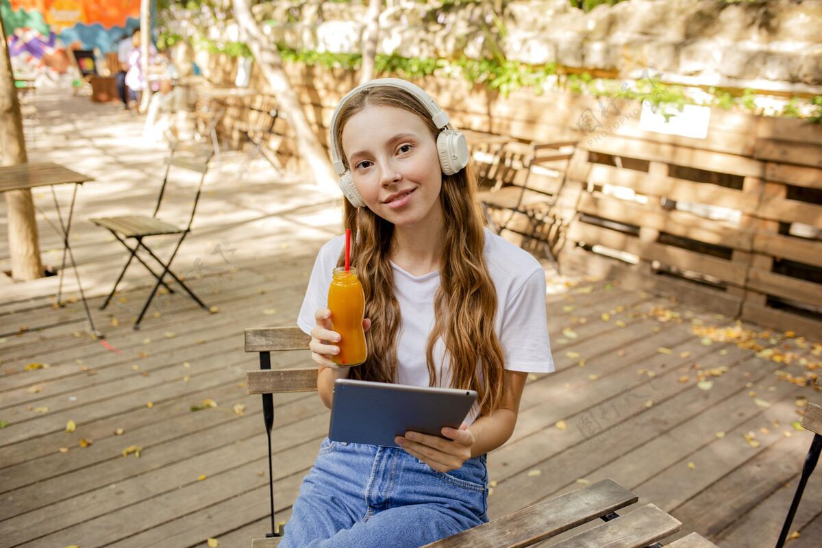健康食品高角度的女孩拿着书和新鲜的果汁瓶热带水果健康水果