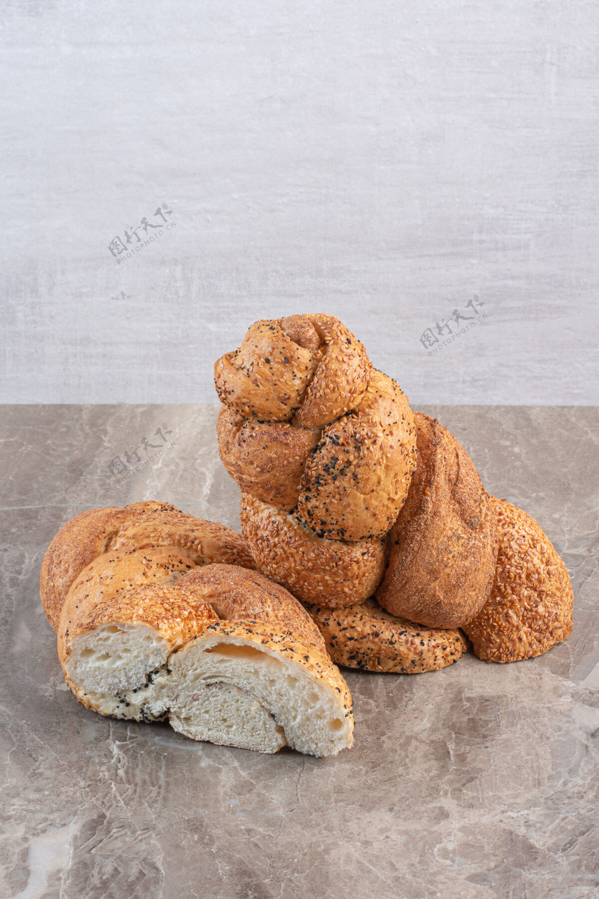 面包在大理石上切成两片的斯特拉西亚面包膳食芝麻烘焙食品