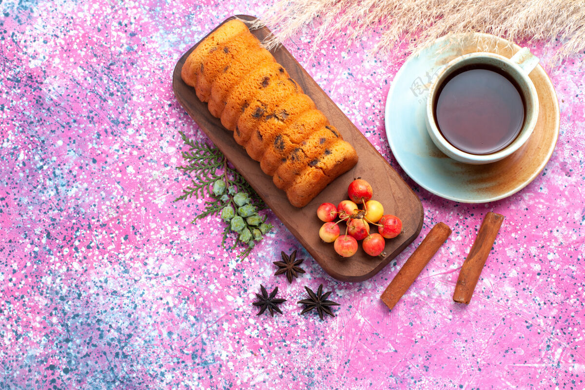 派俯瞰美味的蛋糕 甜甜可口 樱桃 肉桂和一杯茶放在粉红色的桌子上肉桂杯子茶