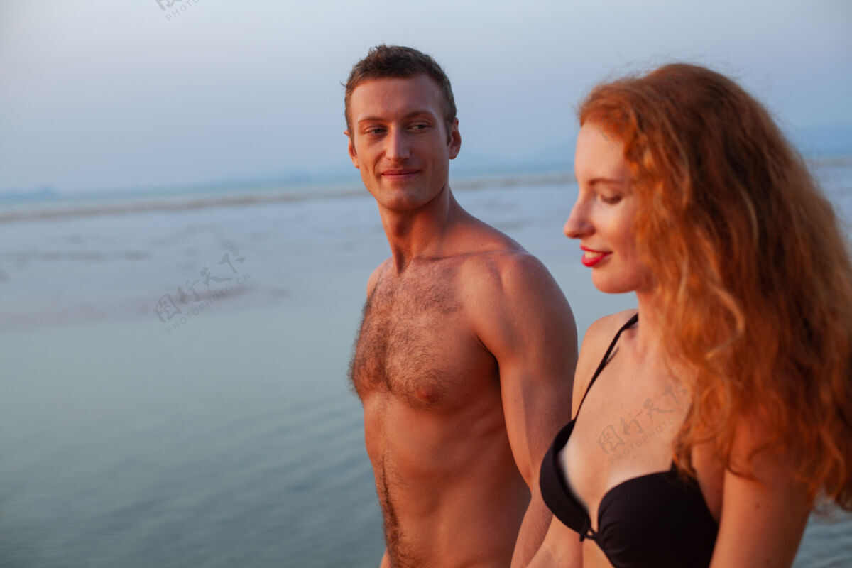 自然年轻性感浪漫的情侣在夏天的沙滩上快乐地穿着泳装玩男性海滩女朋友