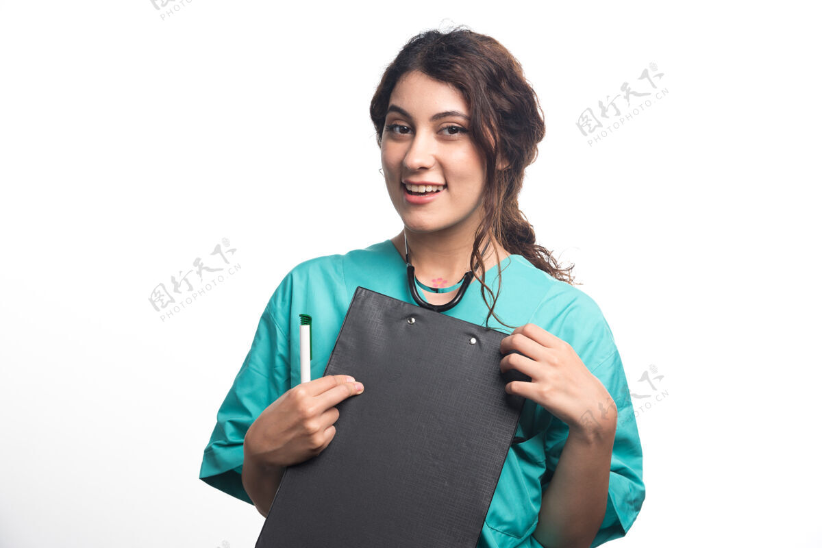 实习生年轻的女医生拿着剪贴板 手里拿着笔 背景是白色的高质量的照片医生治疗师医生